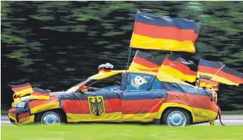  ?? FOTO: DPA ?? Autofahrer im Fußballfie­ber: Auch während der WM ist nicht alles erlaubt, was dem Fan gefällt.