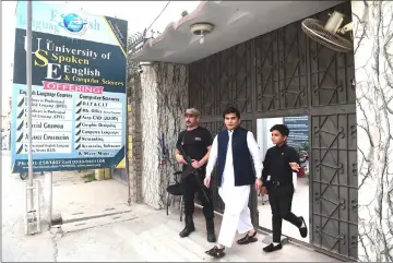  ??  ?? In this picture taken on Apr 3, 11-year-old Pakistani motivation­al coach Hammad Safi (right) walks with his teacher at a languages academy in Peshawar. Elegantly dressed, his gestures confident, Hammad Safi speaks into a wireless microphone before an...