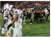  ?? AP/ROSS D. FRANKLIN ?? Michigan State defensive end Kenny Willekes (48) and defensive tackle Mike Panasiuk (72) walk off the field as Arizona State players celebrate a 10-7 victory over the No. 18 Spartans on Saturday in East Lansing, Mich.