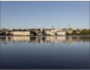  ??  ?? Buildings stand on the edge of Lake Tjornin in Reykjavik, Iceland, in July. (Bloomberg/Sigga Ella)