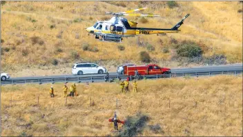  ?? Jeff Zimmerman/For The Signal ?? Los Angeles County Fire Department firefighte­rs hoist a man who was ejected from a vehicle near Interstate 5 and Templin Highway Friday. The man was airlifted to Henry Mayo Newhall Hospital.