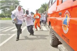  ?? — Gambar AFP ?? PELAJAR menyertai latihan evakuasi tsunami di Meulaboh, Indonesia semalam selepas bencana pada 2004 mengorbank­an lebih 200,000 nyawa.