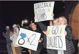  ?? ♦ Jeremy stewart ?? Fans hold signs to welcome back the Rockmart High School wrestling team late Saturday night after its state championsh­ip win in Hazlehurst.