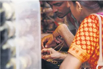  ??  ?? HANDS ON: Customers at a jewellery shop in New Delhi. In Old Delhi’s gold and diamond district, banknotes are still in common use six months after the demonetisa­tion scheme started.