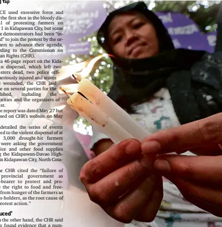  ?? INQUIRER PHOTO ?? A MEMBER of the militant women’s group Gabriela lights a candle during a protest rally in April to denounce the violent dispersal of farmers on a highway in Kidapawan City, North Cotabato province, that killed two protesters and wounded scores of...