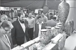  ?? BAHAWALPUR
-APP ?? Federal Minister for Quality Education, Balighur Rehman inspecting handicraft stalls at exhibition at Bahawalpur Arts Council.