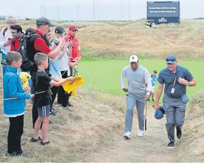  ?? Pictures: Kim Cessford/PA. ?? Fans ask Tiger Woods for his autograph as he takes to the links at Carnoustie yesterday.