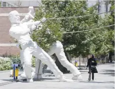  ?? — AFP ?? A woman walks past a sculpture in front of a park in Tehran on Tuesday.