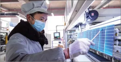  ?? ZHAO MING / FOR CHINA DAILY ?? A worker examines photovolta­ic cells at a workshop of Anhui Daheng Energy Technology Co Ltd in Hefei, Anhui province, on Jan 6. The workshop produces smart solar panels.