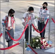  ?? ?? Crow Nation citizens and representa­tives, including students from Plenty Coups High School, lay flowers Tuesday at the front of the Tomb of the Unknown Soldier Plaza.