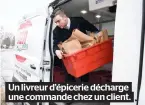  ??  ?? Un livreur d’épicerie décharge une commande chez un client.