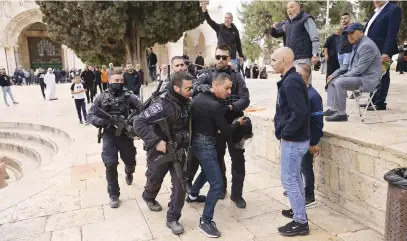  ?? Picture: AFP ?? FEELING THE HEAT. Israeli police restrain a Palestinia­n protester as security forces accompany a group of Jewish visitors past the Dome of the Rock at the Al-Aqsa mosque compound in the Old City of Jerusalem yesterday. It is revered as the site of two ancient Jewish temples and Islam’s third-holiest site.