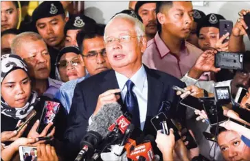  ?? MOHD RASFAN/AFP ?? Former Malaysia’s prime minister Najib Razak (centre) speaks to journalist­s after a court appearance in Kuala Lumpur on September 20.