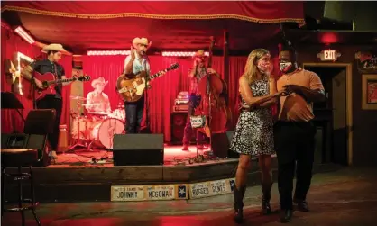  ??  ?? Lloyd Weatherspo­on and Hope Wilson dance in masks at The White Horse on 10 March 2021 in Austin, Texas. Photograph: Tamir Kalifa/ Getty Images