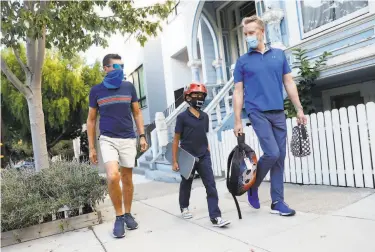  ?? Strazzante / The Chronicle ?? Luis Tamayo ( left), David Thompson and their son, Lucas, 9, head home from Adda Clevenger School.