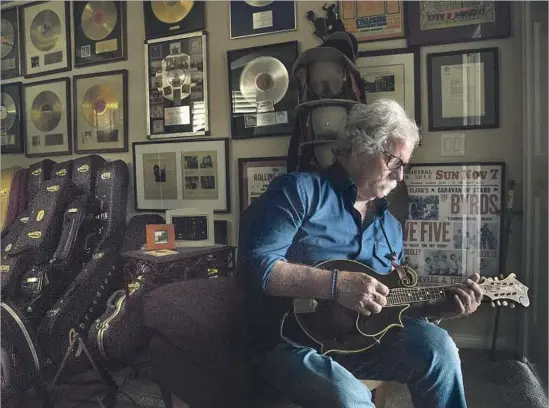  ?? Myung J. Chun Los Angeles Times ?? MUSICIAN Chris Hillman plucks a few notes on his prize possession: a 93-year-old Lloyd Loar F5 Gibson mandolin that was gifted to him by Stephen Stills years ago.