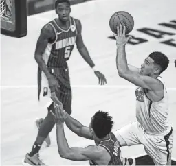  ?? AP ?? The Suns’ Devin Booker (1) shoots over the Pacers’ Malcolm Brogdon (7) during the first half Saturday in Indianapol­is.