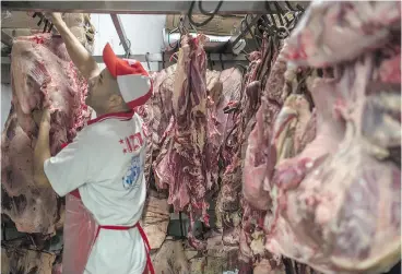  ?? VICTOR MORIYAMA / GETTY IMAGES ?? Butchers work Monday at the popular Lapa Market in Sao Paulo. Brazilian federal police have launched a major corruption probe into the meat-packing industry.