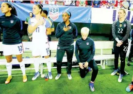  ?? FILE ?? United States’ women’s football team captain Megan Rapinoe (second right) kneels next to teammates (from left) Christen Press, Ali Krieger, Crystal Dunn and Ashlyn Harris as the national anthem is played before the team’s exhibition match against the Netherland­s in Atlanta, Georgia, on Sunday, September 18, 2016.