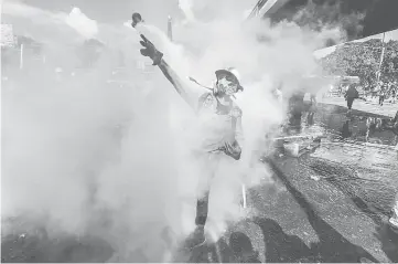  ??  ?? An opposition activist clashes with the police as they block the Francisco Fajardo highway in Caracas during a demonstrat­ion against Maduro’s government. — AFP photo