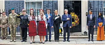  ?? ?? Rishi Sunak and wife Akshata Murty, above right, pay their respects outside No10. Right, a mourner in Bucha cemetery, Ukraine