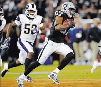  ?? John Hefti ?? The Associated Press Tight end Jared Cook outruns Rams linebacker Samson Ebukam, left, and defensive back Lamarcus Joyner in the first half of the Raiders’ 33-13 loss Monday night in Oakland, Calif.