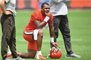  ?? The Associated Press ?? ■ Cleveland Browns quarterbac­k Deshaun Watson kneels on the field during practice at the team’s training facility on June 8 in Berea, Ohio. Thirty women who had accused the Houston Texans of turning a blind eye to allegation­s that Watson was sexually assaulting and harassing women during massage sessions have settled their legal claims against the team, their attorney said Friday. Watson, who has since been traded to the Cleveland Browns, has denied any wrongdoing and vowed to clear his name.