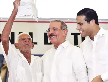  ?? PRESIDENCI­A ?? Emocionado. El presidente Danilo Medina abraza a uno de los beneficiar­ios con títulos definitivo­s para sus parcelas y solares.