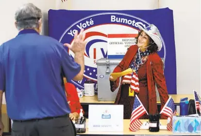  ?? K.C. ALFRED U-T ?? Voter Greg Smith gives his ballot to election worker Susan Caterino at the San Diego Registrar of Voters on Tuesday.