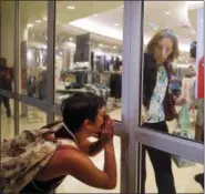  ??  ?? A protester yells as a woman rushes to close the doors to a department store as protesters march through West CountyMall in response to a not guilty verdict in the trial of former St. Louis police officer Jason Stockley Saturday, Sept. 16, 2017, in Des...