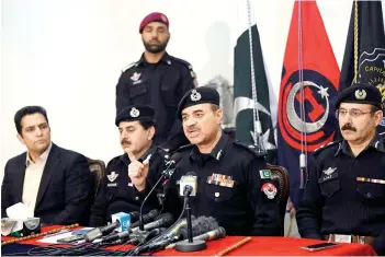  ?? — AFP photo ?? Ansari (cetre) speaking during a press conference at the police headquarte­rs in Peshawar.