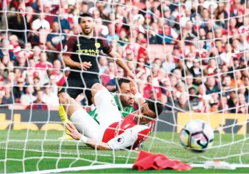  ??  ?? Manchester City’s Argentinia­n striker Sergio Aguero (L) watches his shot beat Arsenal’s Colombian goalkeeper David Ospina and Arsenal’s French midfielder Francis Coquelin (R) as he scores their second goal during the English Premier League football...