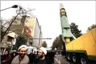  ?? ATTA KENARE/AFP PHOTO ?? PAMER: Warga berpose di depan replika Ghadr, misil jarak menengah milik Iran, yang dibawa dalam demo di depan Kedubes AS di Teheran kemarin.