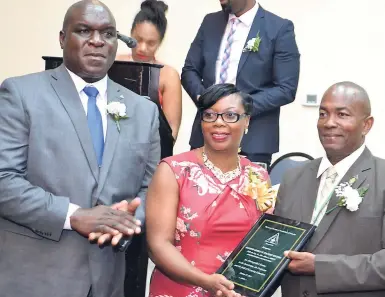  ?? CONTRIBUTE­D ?? Noel Brown (left), president, Land Surveyors’ Associatio­n of Jamaica, looks on as Glendon Newsome (right), commission­ed land surveyor, collects the award from Verene Brown, president of the Land Surveyors Wives Associatio­n.