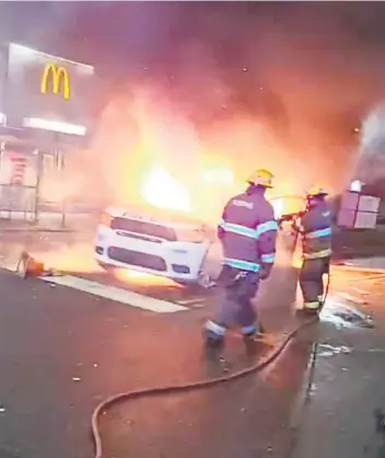  ?? PHOTO REUTERS ?? Une voiture de police a été incendiée par les manifestan­ts en colère dans la nuit de lundi à hier à Philadelph­ie. Plusieurs commerces ont aussi été pillés et vandalisés.