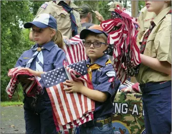  ?? DaviD MeKeel — MeDianeWS groUP ?? cub Scouts cali Peifer, 8, and lucas Stahl, 6, hand out american flags during a flag retirement ceremony Saturday, aug. 28, at Zion Spies evangelica­l reformed church in alsace township. the event was held by veterans Making a Difference.