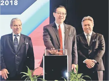  ?? Badri. — Bernama photo ?? Lim (middle) officiates the National Tax Seminar 2018 yesterday. Also seen are Sabin (right) and Ahmad