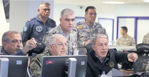  ?? AFP ?? Turkey’s Defence Minister Hulusi Akar, right, chairs a new air operation in northern regions of Iraq and Syria with members of the Turkish Armed Forces (TSK) command level at the Turkish Air Force Operations Centre in Ankara yesterday.