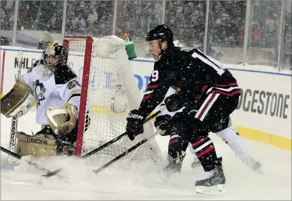  ?? — GETTY IMAGES ?? Jonathan Toews of the Blackhawks battles for the puck in the NHL Stadium Series game against the Penguins on Saturday at Soldier Field in Chicago. Toews had two goals and an assist as the Blackhawks defeated Pittsburgh handily 5-1.