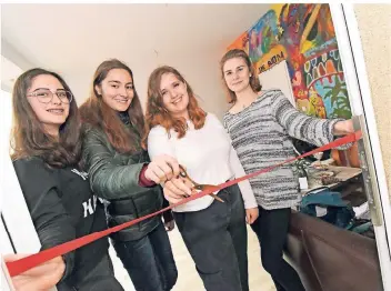  ??  ?? Tabea (17), Lisa (16), Kristin (16) und Hannah (16; von links) schneiden bei der Eröffnung das rote Band für den neuen Jugendtref­f an der Lange Straße durch.