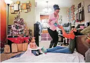  ?? [PHOTO BY DOUG HOKE,
THE OKLAHOMAN] ?? Mykel Jones brings dinner to her daughters, Lakel Tipton, 10, and Alani King, 1, Dec. 22 in Oklahoma City. Since they don’t have a table, they spread a cloth out in the front room and eat on the floor.