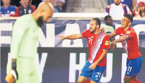  ??  ?? FIGURA. Marco Ureña celebra con Johan Venegas uno de sus dos goles mientras Tim Howard lo lamenta.