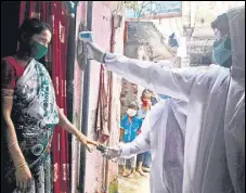  ?? ANI ?? Health care workers wearing PPE kits examine residents living in the slum area at Malad in Mumbai on Wednesday.