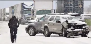  ?? AP ?? A man walks past the scene of a car crash in Leroy, Ohio.