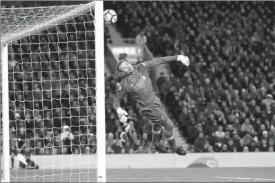  ?? CARL RECINE / ACTION IMAGES VIA REUTERS ?? Liverpool goalkeeper Simon Mignolet dives in vain as Willian’s 85th-minute equalizer whistles past him to earn Chelsea a 1-1 Premier League draw at Anfield on Saturday.