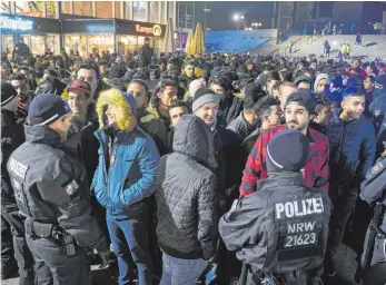  ?? FOTO: DPA ?? Polizisten umringen in der Silvestern­acht vor dem Hauptbahnh­of in Köln eine Gruppe Männer.