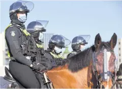  ?? PHOTOS BY AFP ?? Police on horseback patrol the Shrine of Remembranc­e enforcing the wearing of face masks in Melbourne yesterday.