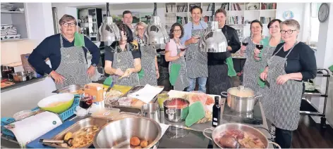  ?? RP-FOTO: THOMAS LAMMERTZ ?? Die Gewinner des RP-Gewinnspie­ls am Herd in der Kochschule von Delikatess­en Franken. In den Töpfen brutzeln spanische Leckereien.