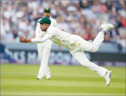  ??  ?? Pakistan’s Mohammad Amir dives and catches the ball to dismiss England’s Mark Wood off the bowling of Pakistan’s Mohammad Abbas during the first
day of play of the first Test cricket match between England and Pakistan at Lord’s cricket ground in...