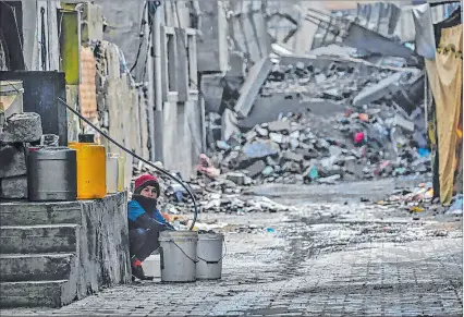  ?? EFE ?? Gaza. Un niño llena un cubo con agua entre los escombros en el campo de refugiados de Al Nusairat.